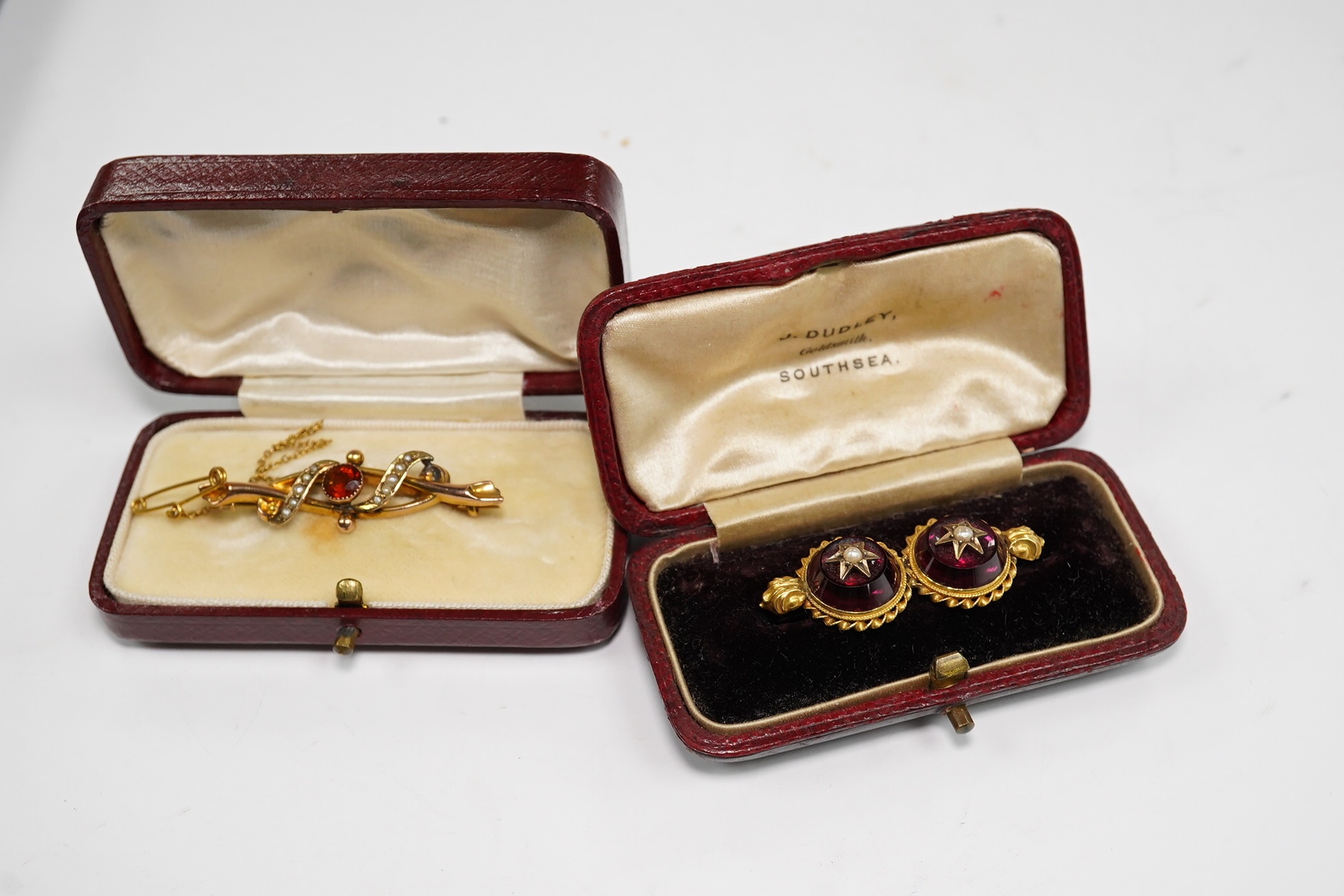 An Edwardian 9ct gold, hessonite garnet and seed pearl cluster set bar brooch, 42mm and a Victorian yellow metal, garnet and seed pearl set bar brooch, gross weight 7.3 grams, Condition - fair to good